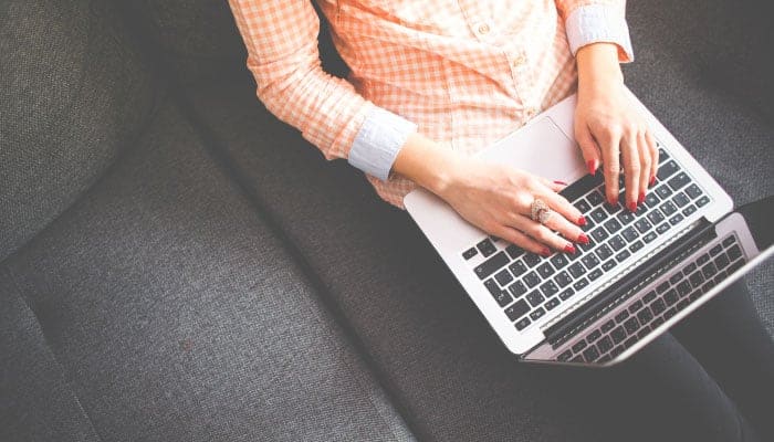 person sitting on couch using laptop