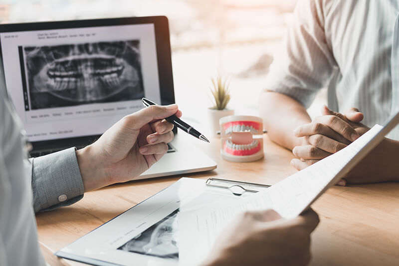 two people discussing dental paperwork