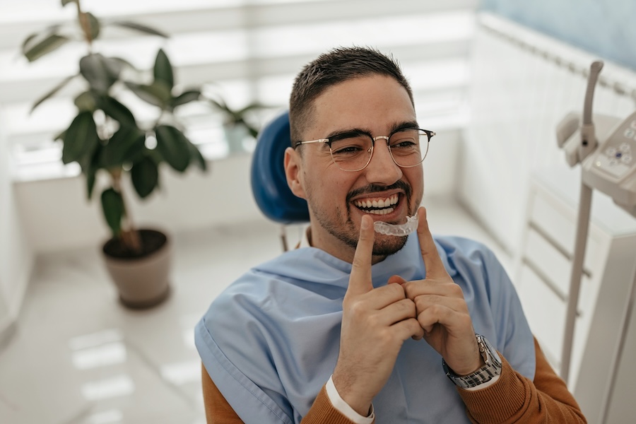 Man holding invisalign clear aligners for orthodontics