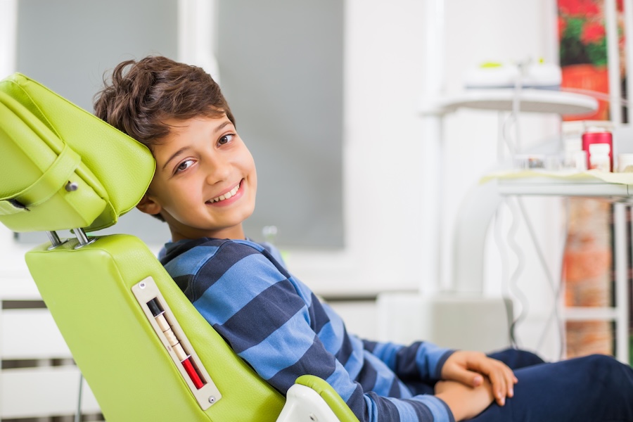 young boy in dental chair for routine dental visit for children