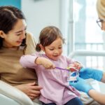 child at a dental visit with their parent, child's first dental appointment