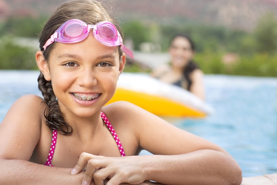 child wearing braces while swimming after consultation to determine if a child needs braces