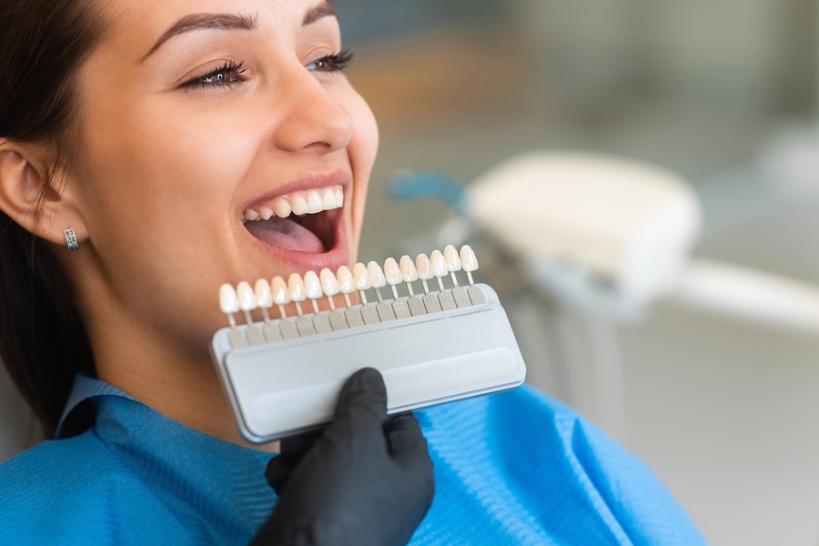 woman at dentist getting shade matched for porcelain veneers