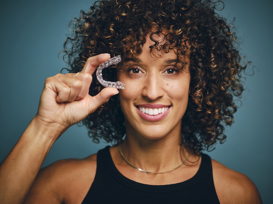 woman holding invisalign clear aligners