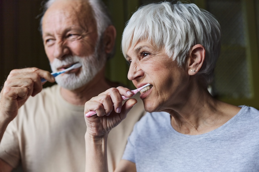 senior couple brushing their teeth for senior dental care