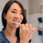 woman brushing her teeth to prevent periodontal disease or gum disease