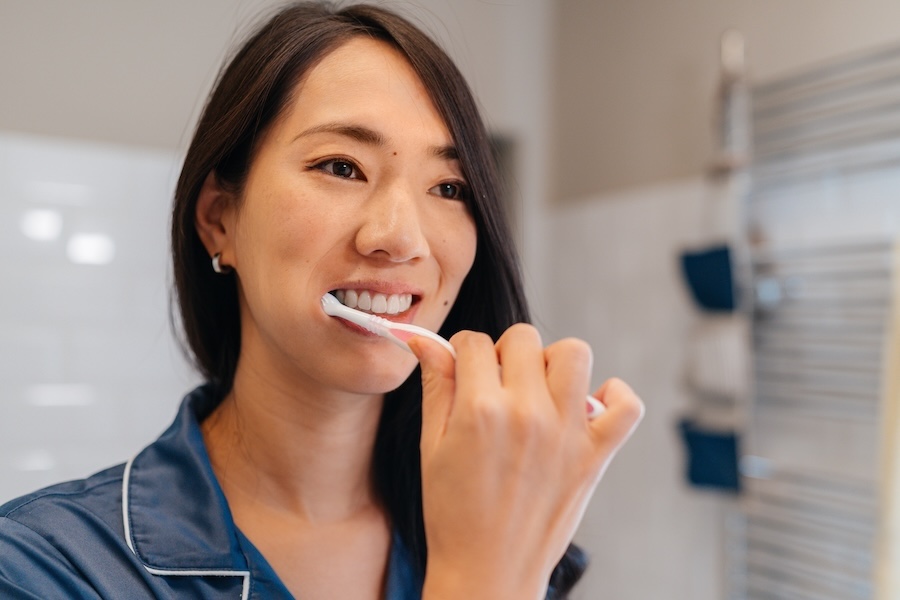 woman brushing her teeth to prevent periodontal disease or gum disease