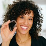 woman holding invisalign clear aligners
